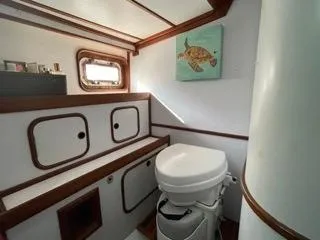 Slide: The Image of 1984 Tayana 55 yacht bathroom with marine toilet and storage cabinets. - 14