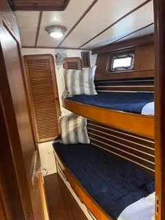 Slide: The Image of 1984 Tayana 55 yacht interior with wooden bunk beds and nautical decor. - 20