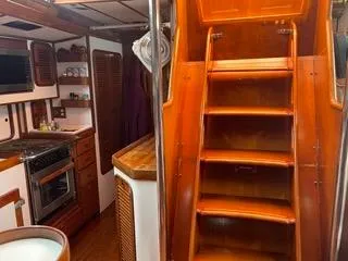 Slide: The Image of Interior of 1984 Tayana 55 sailboat with wooden stairs and kitchen area. - 36