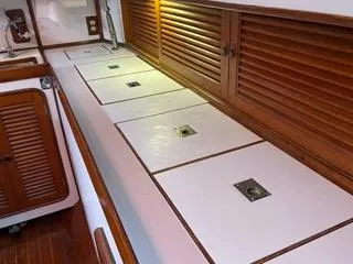 Slide: The Image of Interior storage area of 1984 Tayana 55 sailboat with wooden cabinets and white countertops. - 4