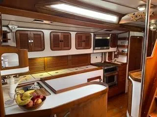 Slide: The Image of Interior of 1984 Tayana 55 yacht kitchen with wooden cabinets and modern appliances. - 7