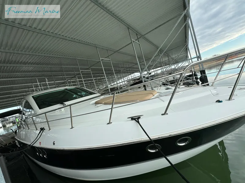 Slide: The Image of 2014 Cruisers Yachts 540 Sports Coupe docked under a covered marina. - 31