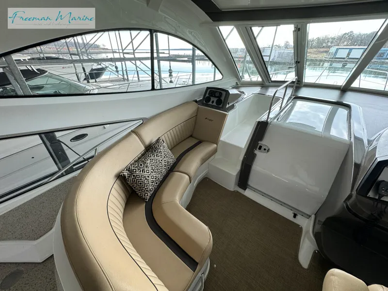 Slide: The Image of 2014 Cruisers Yachts 540 Sports Coupe interior with tan seating and large windows. - 48