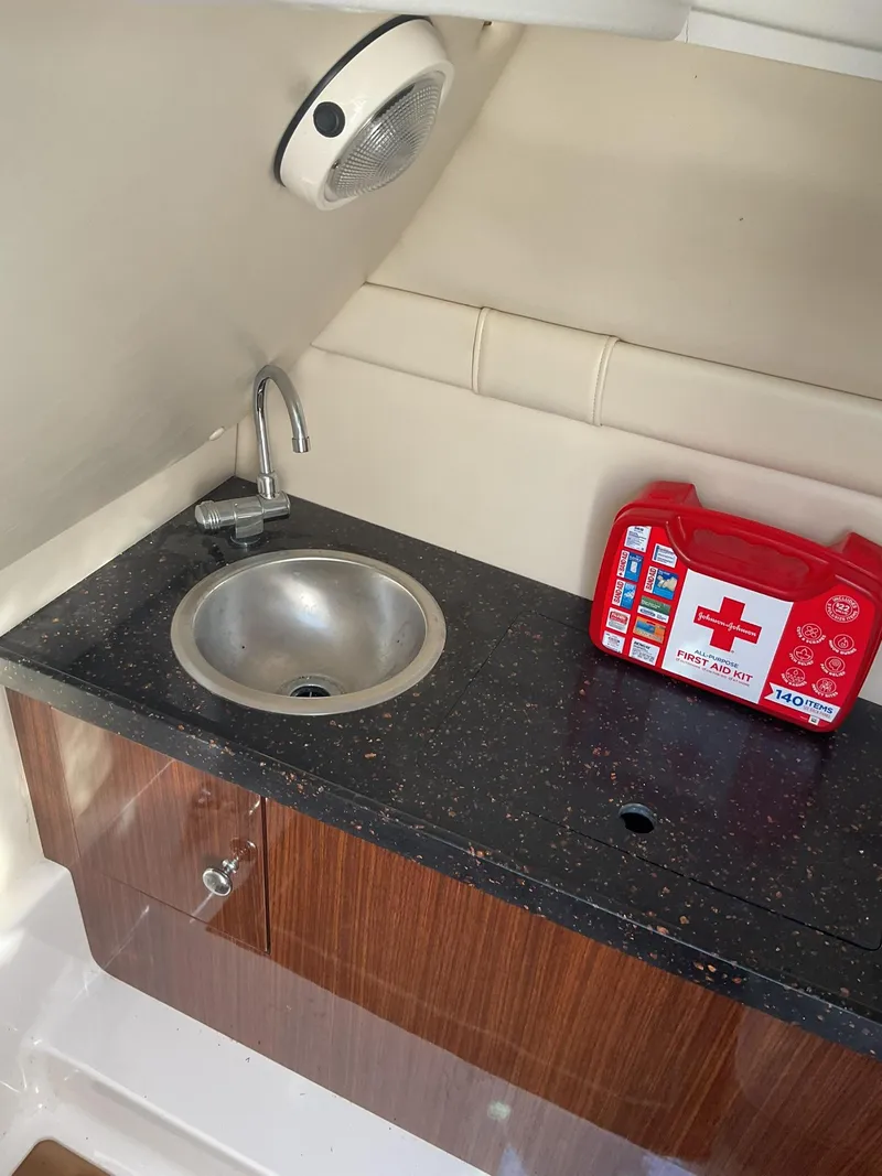 Slide: The Image of 2013 Regal 27 FasDeck RX boat interior with sink and first aid kit - 11