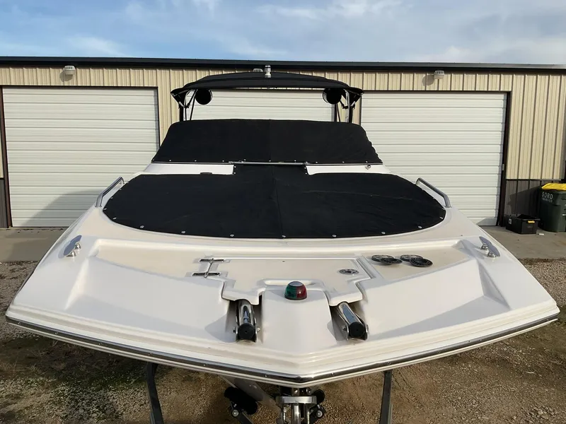 Slide: The Image of 2013 Regal 27 FasDeck RX boat with black cover in front of storage units. - 18