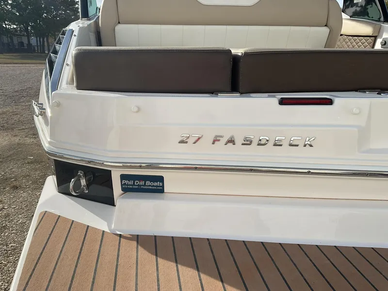 Slide: The Image of 2013 Regal 27 FasDeck RX boat rear view with seating and branding. - 7