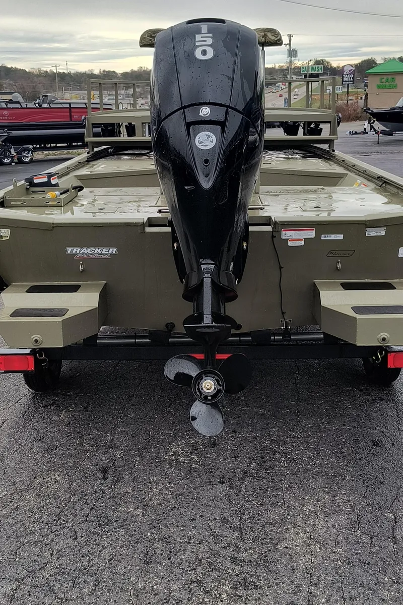 Slide: The Image of 2024 Tracker Grizzly 2072 CC Sportsman boat rear view with outboard motor. - 2
