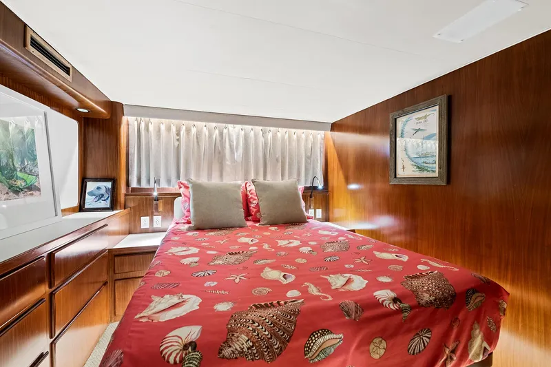Slide: The Image of Cozy bedroom in 1989 Hatteras 70 Motor Yacht with red seashell-themed bedding. - 21