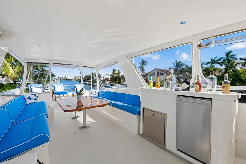 Slide: The Image of 1989 Hatteras 70 Motor Yacht interior with blue seating and bar area. - 45