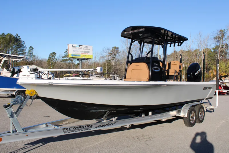 Slide: The Image of 2025 Sea Pro 250 Bay boat on trailer, parked outdoors, clear sky background. - 0