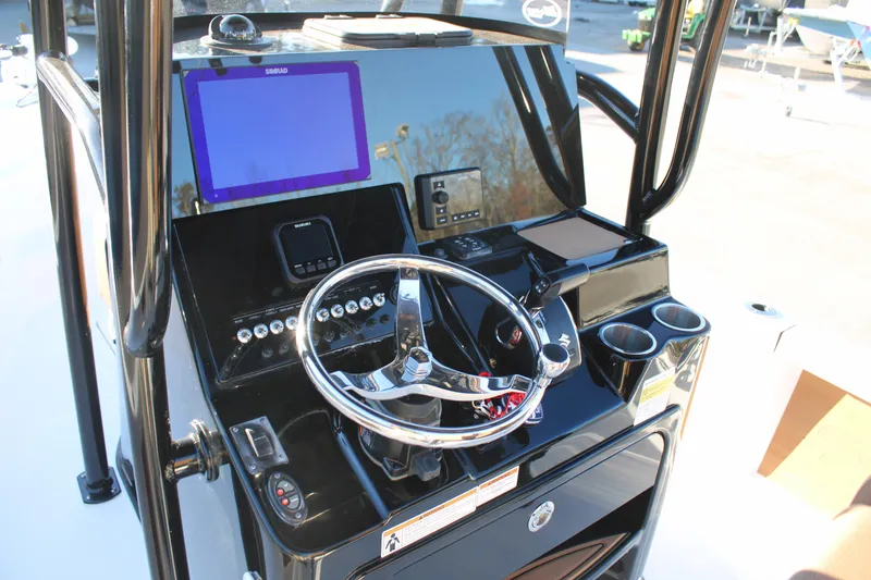 Slide: The Image of 2025 Sea Pro 250 Bay boat console with steering wheel, navigation screens, and controls. - 16