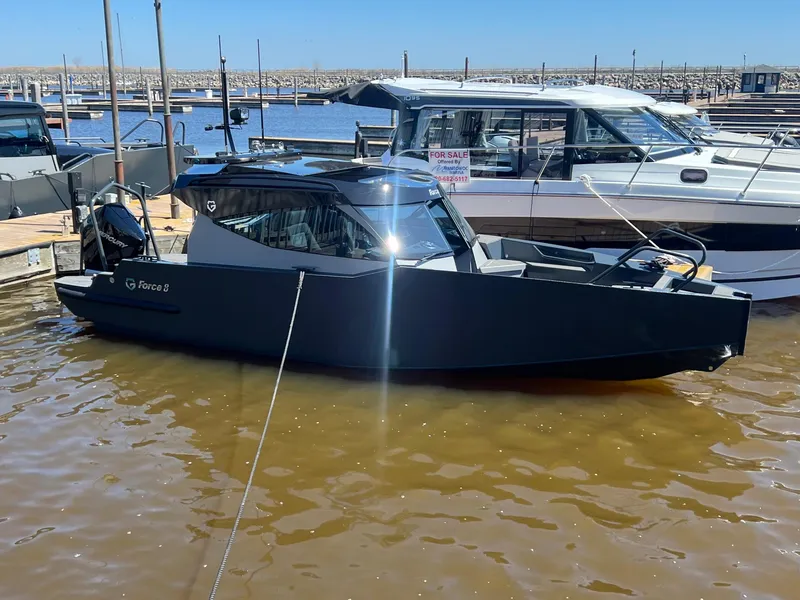 Slide: The Image of 2024 G-Force 8 boat docked at marina, sleek black design, sunny day. - 30