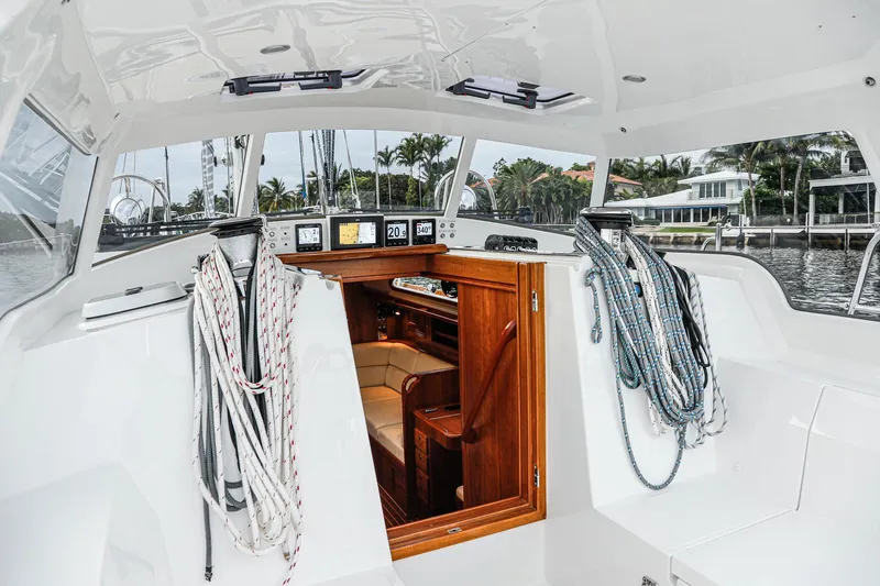 Slide: The Image of Outbound 46 yacht cockpit, 2025 model, featuring ropes and a wooden cabin entrance. - 12