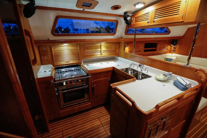 Slide: The Image of Luxurious 2025 Outbound 46 yacht kitchen with wood cabinetry and modern appliances. - 15