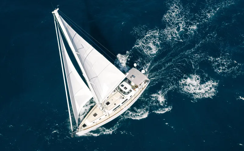 Slide: The Image of Aerial view of 2025 Outbound 46 sailboat navigating through deep blue ocean waters. - 2