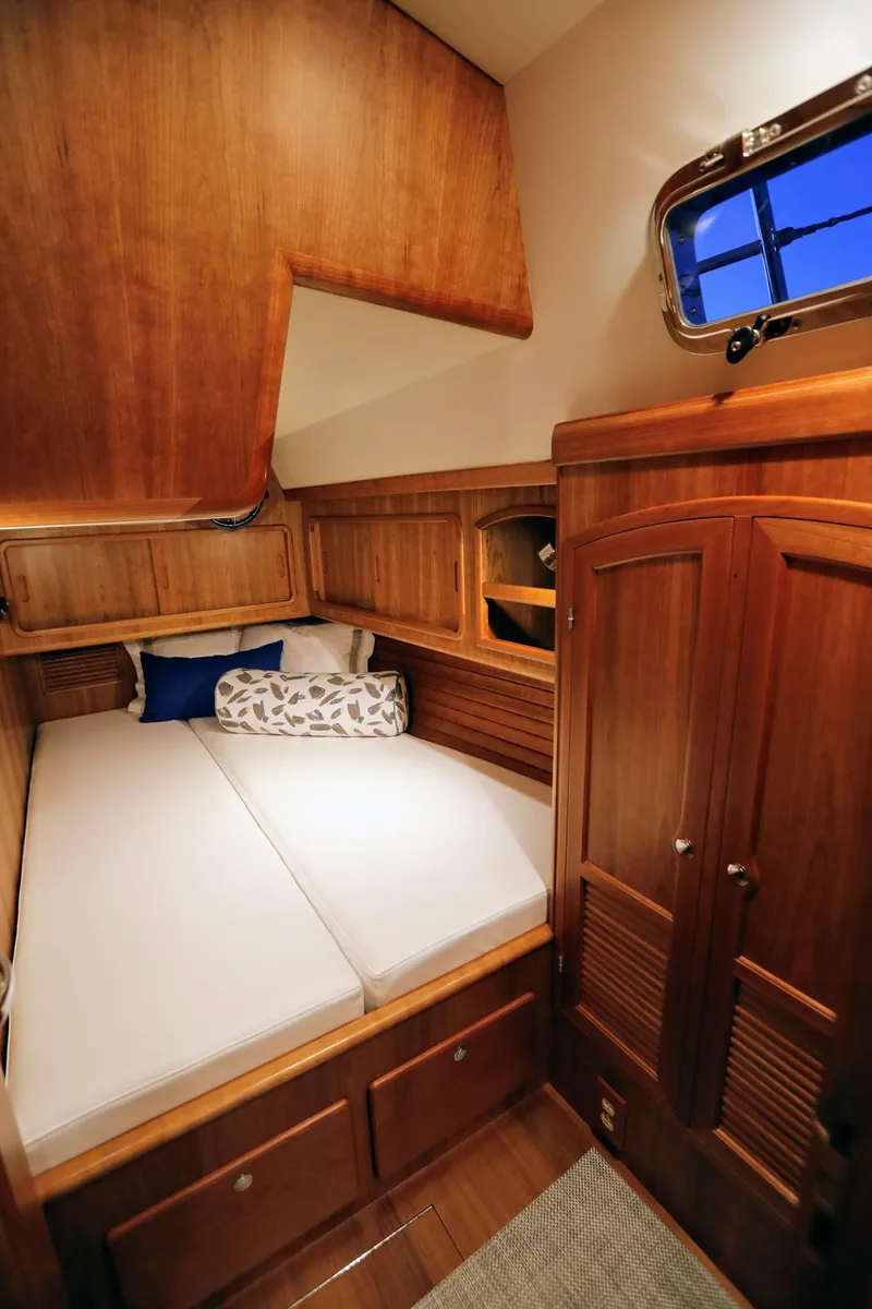 Slide: The Image of 2025 Outbound 46 yacht cabin with wooden interior and cozy bed. - 23