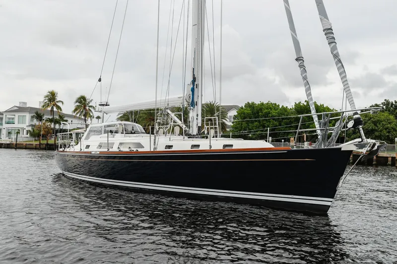 Slide: The Image of Outbound 46 sailboat, 2025 model, docked on a calm waterway with lush greenery. - 6