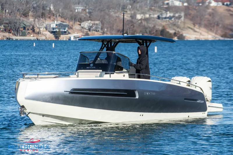 Slide: The Image of 2024 Invictus TT280S boat cruising on a lake with a person at the helm. - 16