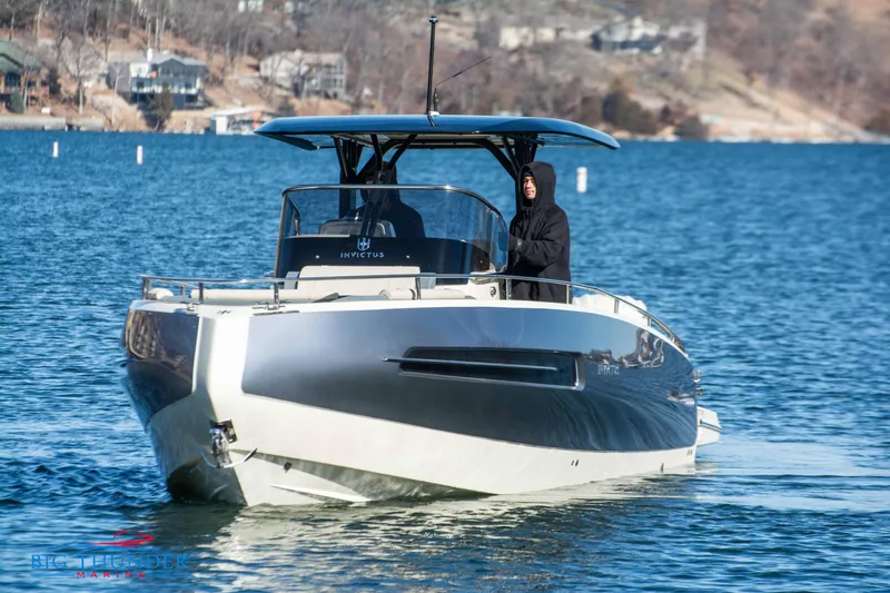 Slide: The Image of 2024 Invictus TT280S luxury motorboat cruising on a serene lake. - 4