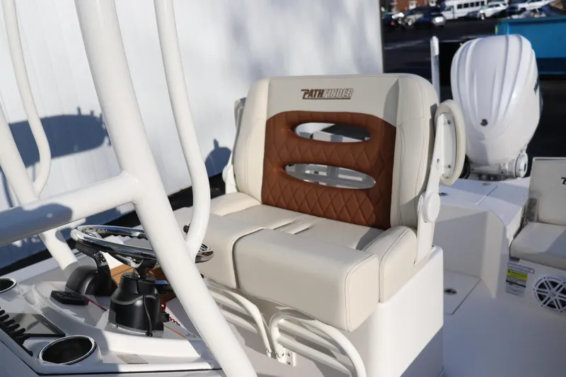 Slide: The Image of 2024 Pathfinder 2500 Hybrid boat interior with cushioned seating and steering console. - 18