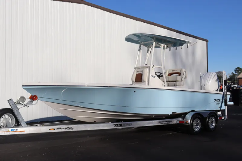 Slide: The Image of 2024 Pathfinder 2500 Hybrid boat on a trailer, light blue hull, parked outdoors. - 2