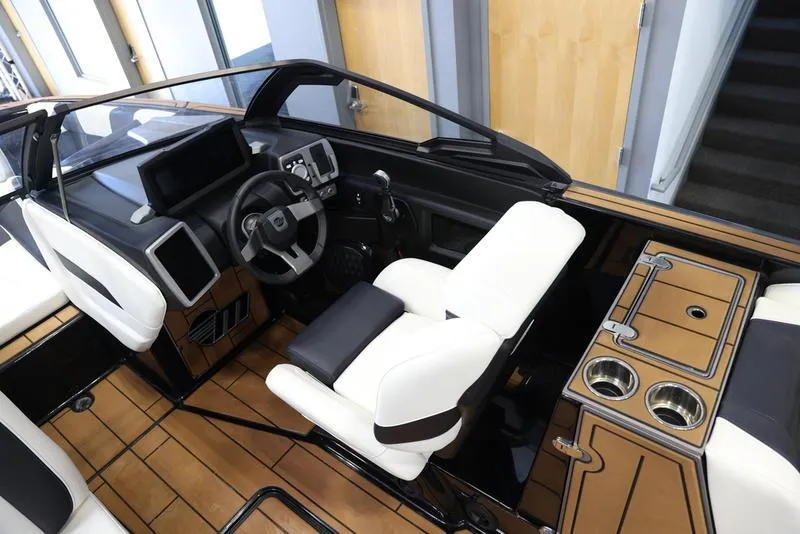 Slide: The Image of 2024 Malibu 24 MXZ boat cockpit with modern dashboard and luxurious seating. - 13