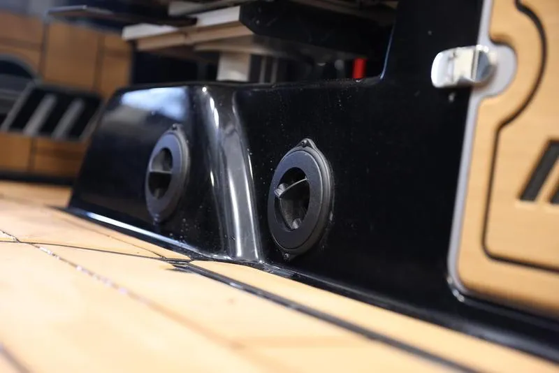 Slide: The Image of Close-up of the 2024 Malibu 24 MXZ boat's black hull and deck details. - 15