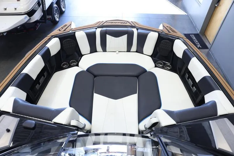 Slide: The Image of 2024 Malibu 24 MXZ boat interior with black and white seating. - 17
