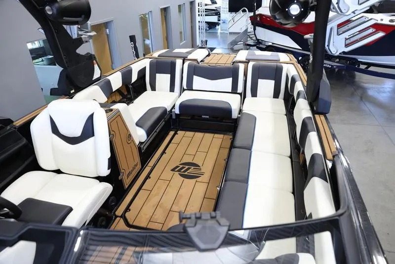 Slide: The Image of 2024 Malibu 24 MXZ boat interior with white and black seating. - 21