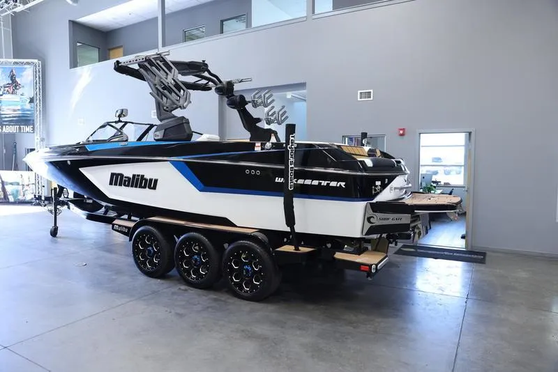 Slide: The Image of 2024 Malibu 24 MXZ boat on a trailer in a showroom. - 4