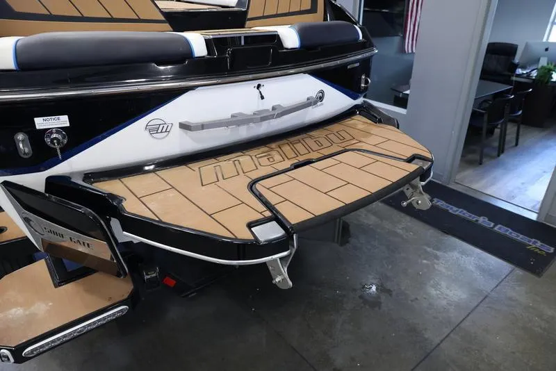 Slide: The Image of 2024 Malibu 24 MXZ boat rear view with swim platform in showroom. - 6