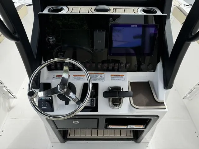 Slide: The Image of 2024 Yamaha Boats 255 FSH Sport E dashboard with steering wheel and control panel. - 6