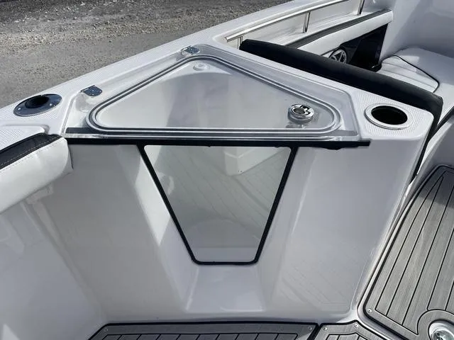 Slide: The Image of 2024 Yamaha Boats 255 FSH Sport H interior with storage compartment and cup holders. - 16