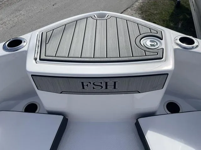 Slide: The Image of 2024 Yamaha Boats 255 FSH Sport H bow with cup holders and storage compartment. - 19