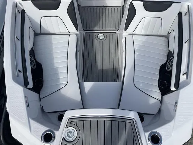 Slide: The Image of 2024 Yamaha Boats 255 FSH Sport H interior with sleek white seating and gray flooring. - 20