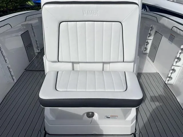 Slide: The Image of 2024 Yamaha Boats 255 FSH Sport H, white cushioned seating, sleek design. - 22