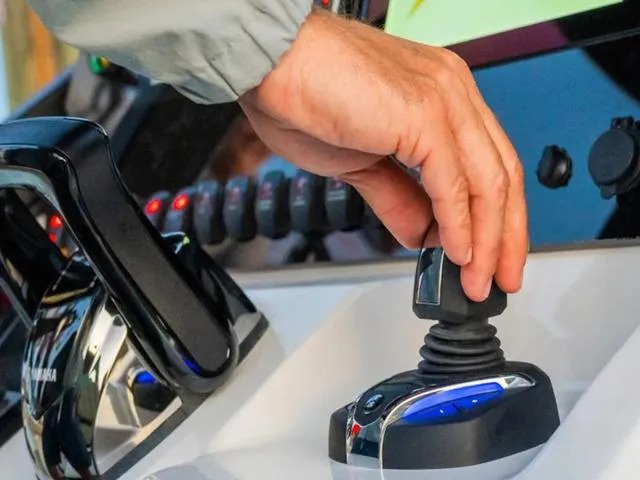 Slide: The Image of Hand operating controls on 2024 Yamaha Boats 255 FSH Sport H dashboard. - 35