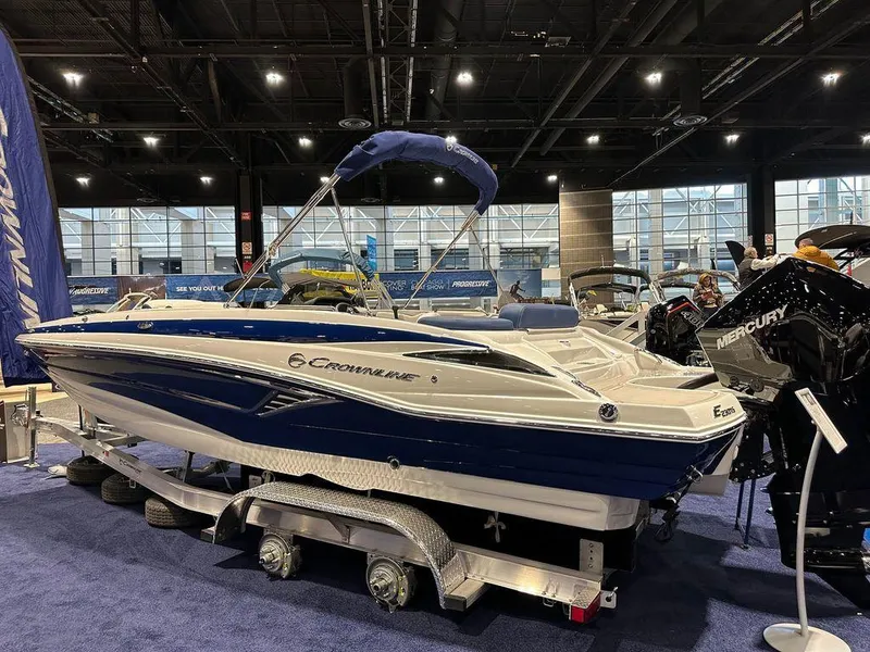 Slide: The Image of 2024 Crownline E230 XS boat on display at an indoor boat show. - 1