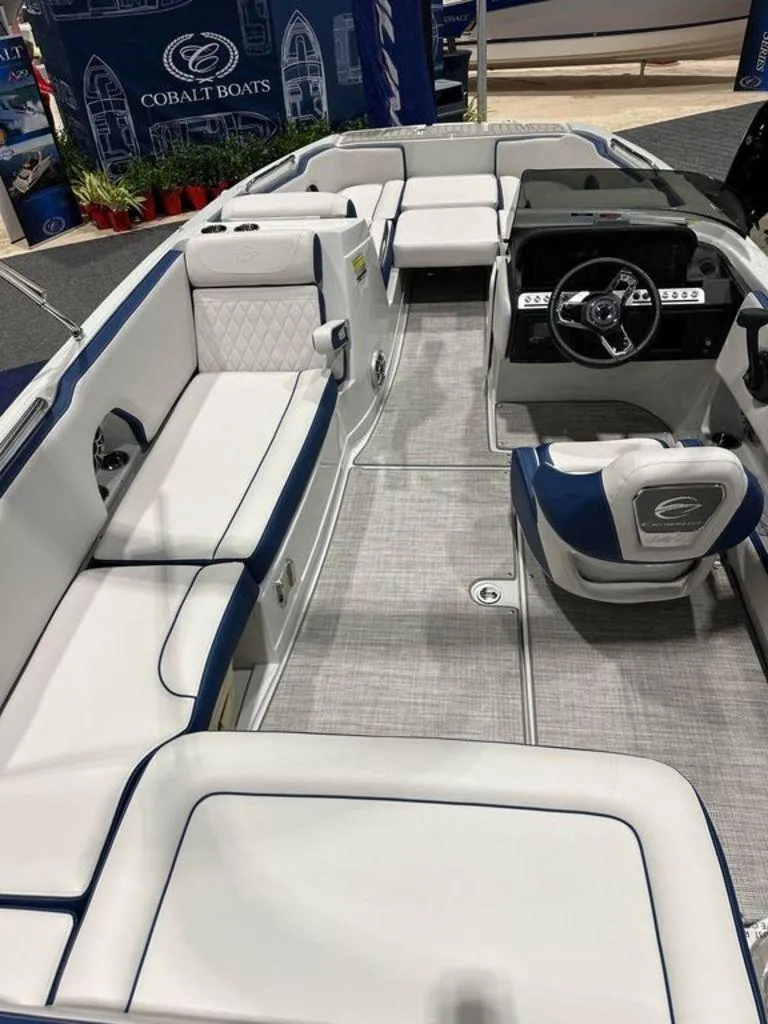 Slide: The Image of 2024 Crownline E230 XS boat interior with white and blue seating, modern dashboard. - 2