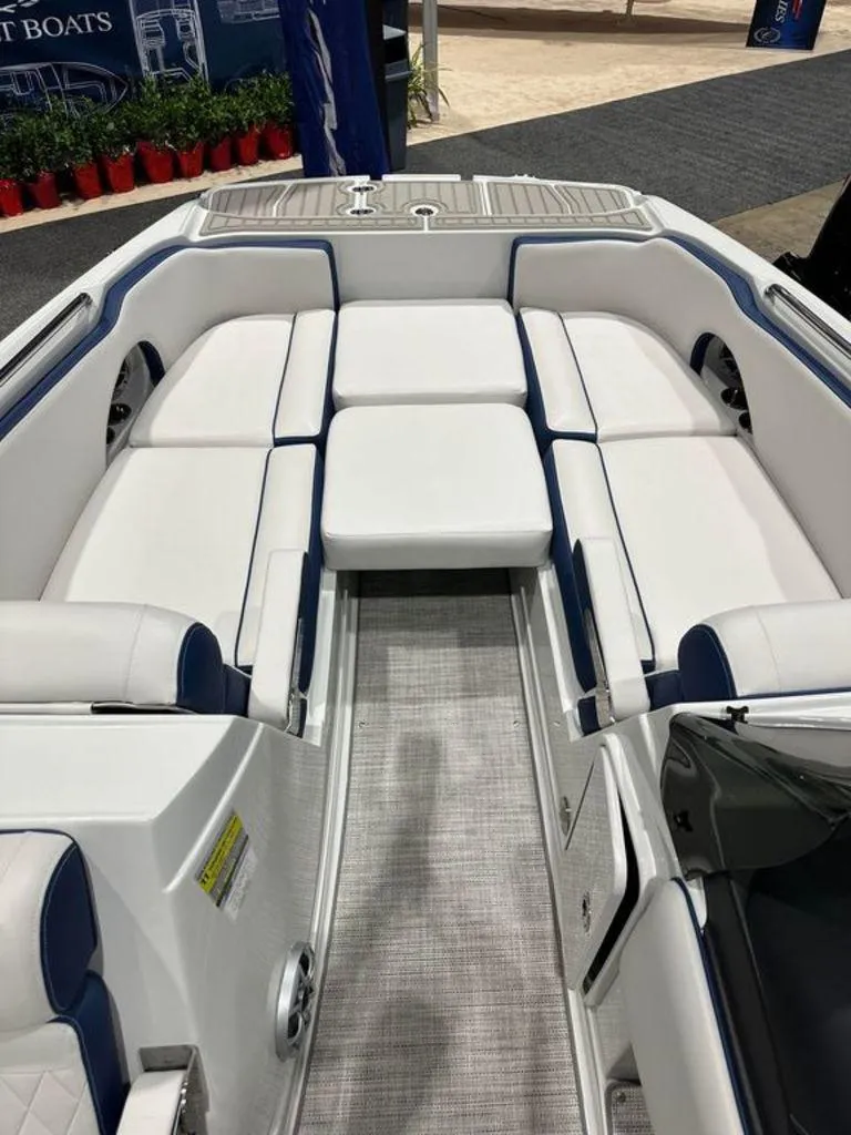 Slide: The Image of 2024 Crownline E230 XS boat interior with white and blue cushioned seating. - 4