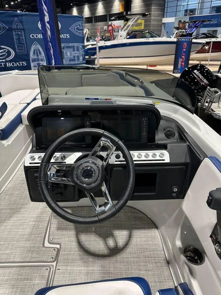 Slide: The Image of 2024 Crownline E230 XS boat dashboard and steering wheel at a boat show. - 6