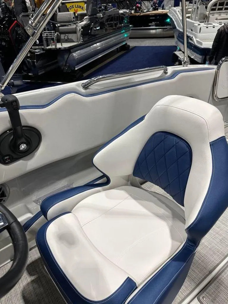 Slide: The Image of Captain's seat of the 2024 Crownline E230 XS boat, featuring blue and white upholstery. - 7