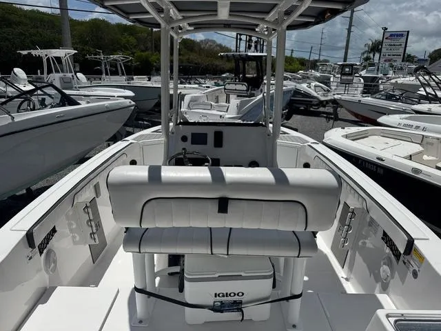 Slide: The Image of 2024 Yamaha Boats 222 FSH Sport, white interior, docked among other boats. - 23
