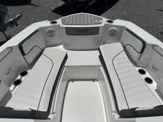 Slide: The Image of 2024 Yamaha Boats 222 FSH Sport interior with white seating and cup holders. - 28