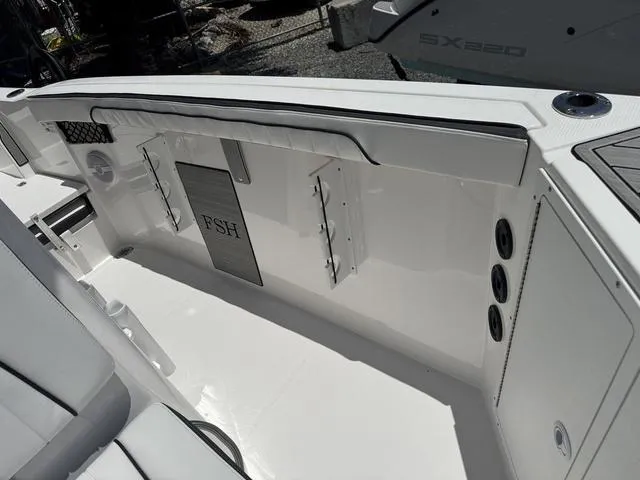 Slide: The Image of 2024 Yamaha Boats 222 FSH Sport interior, featuring sleek white seating and storage compartments. - 35
