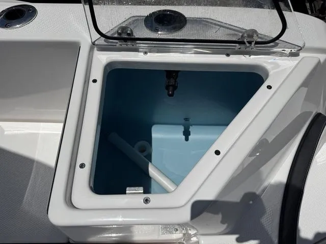 Slide: The Image of 2024 Yamaha Boats 222 FSH Sport storage compartment with open lid, showcasing interior space. - 41