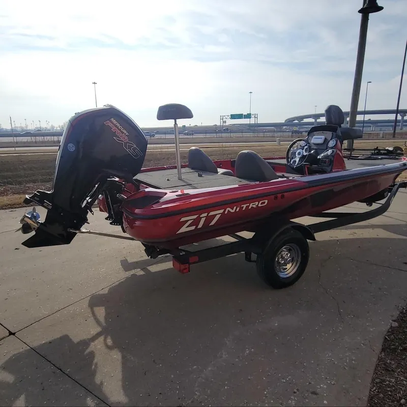Slide: The Image of 2024 Nitro Z17 boat with trailer, red and black, parked outdoors. - 5