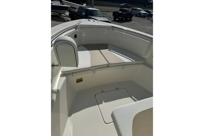 Slide: The Image of 2026 Bulls Bay 230 CC boat interior with cushioned seating and storage compartment. - 12