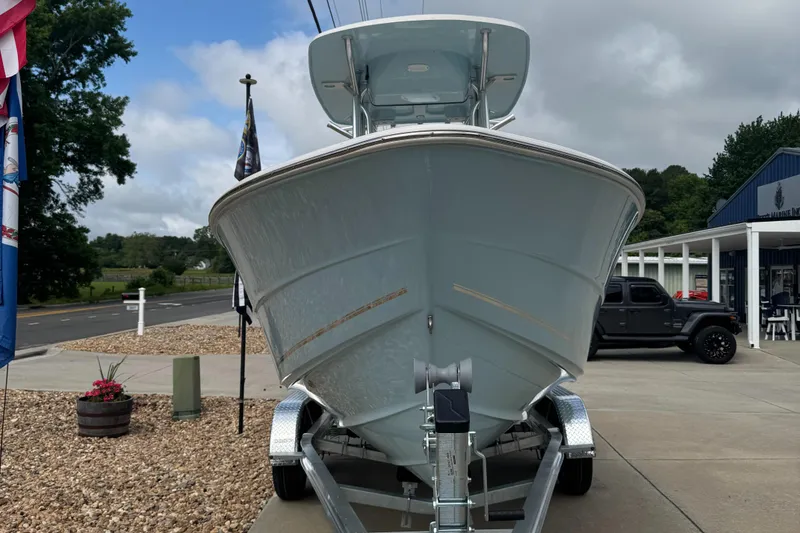 The Image of 2026 Bulls Bay 230 CC boat on trailer, parked outside a blue building. - 2