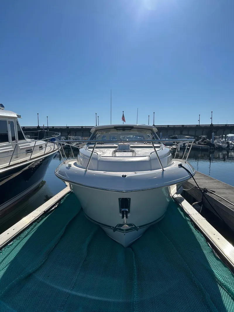 Slide: The Image of 2024 Pursuit OS 405 Offshore boat docked in marina under clear blue sky. - 2